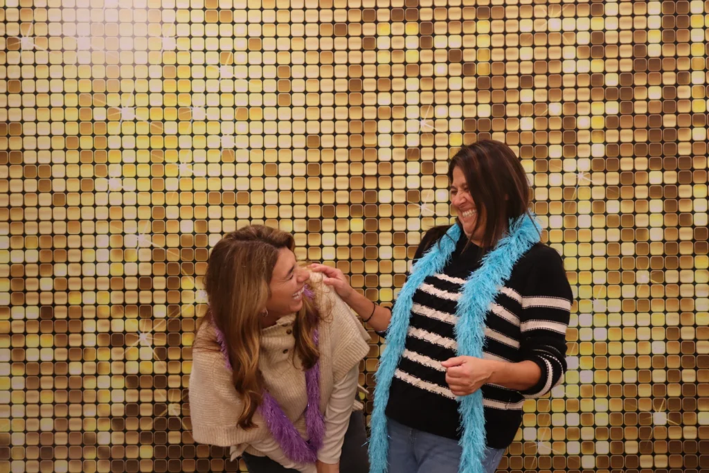 Guests sharing a joyful beÜtiful Pixels photo booth moment with laughter and connection