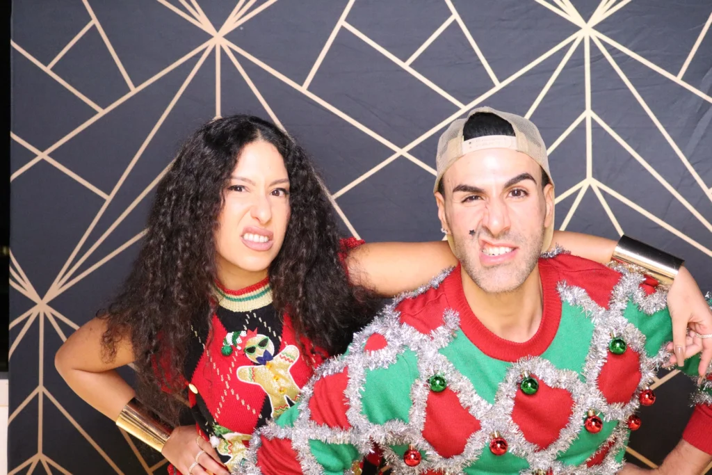 Two guests showing playful personality at a beÜtiful Pixels photo booth in festive outfits