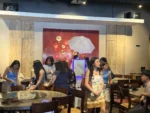Self-serve digital photo booth centered inside an event dining space with round tables and graduation decor.